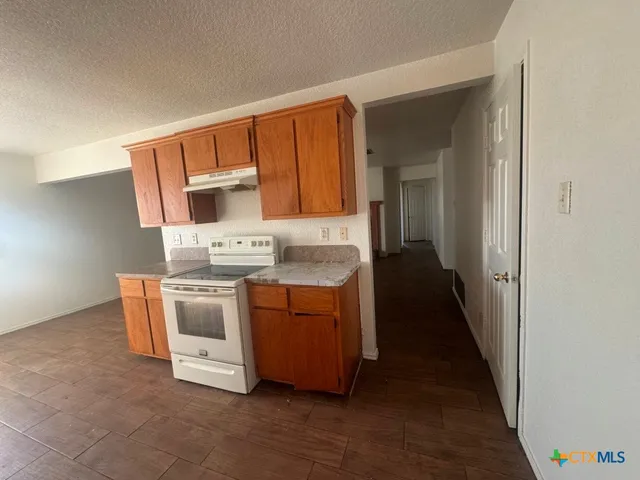 a kitchen with stainless steel appliances a stove top oven