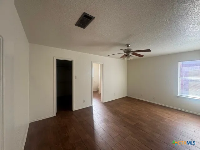 a view of empty room with wooden floor and window