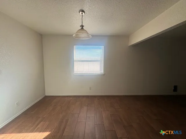 a kitchen with granite countertop a refrigerator and a stove top oven