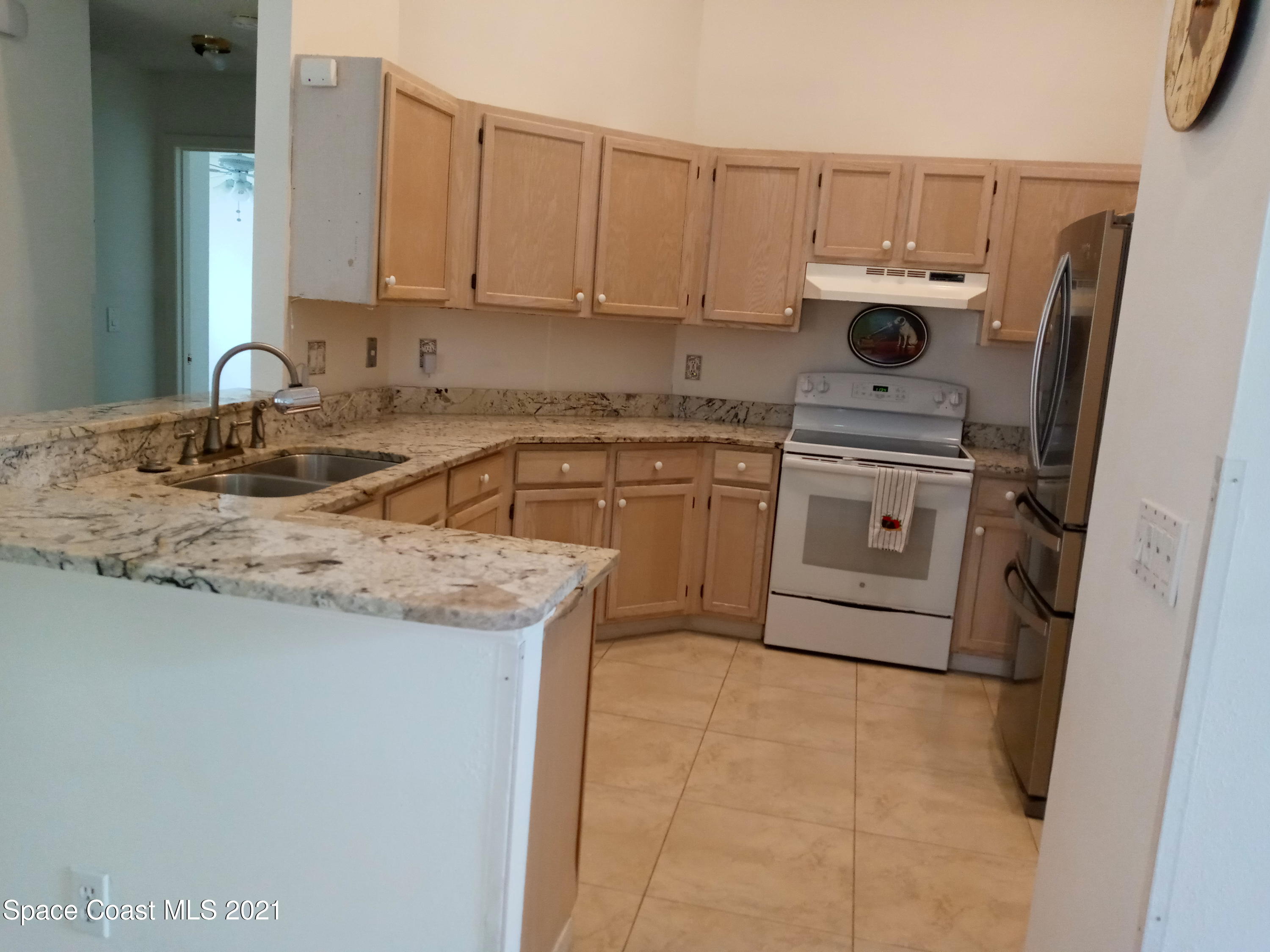 798 Riviera Drive Northeast Palm Bay, FL 32905 - Photo 4 of 7 a kitchen with a sink stove and cabinets