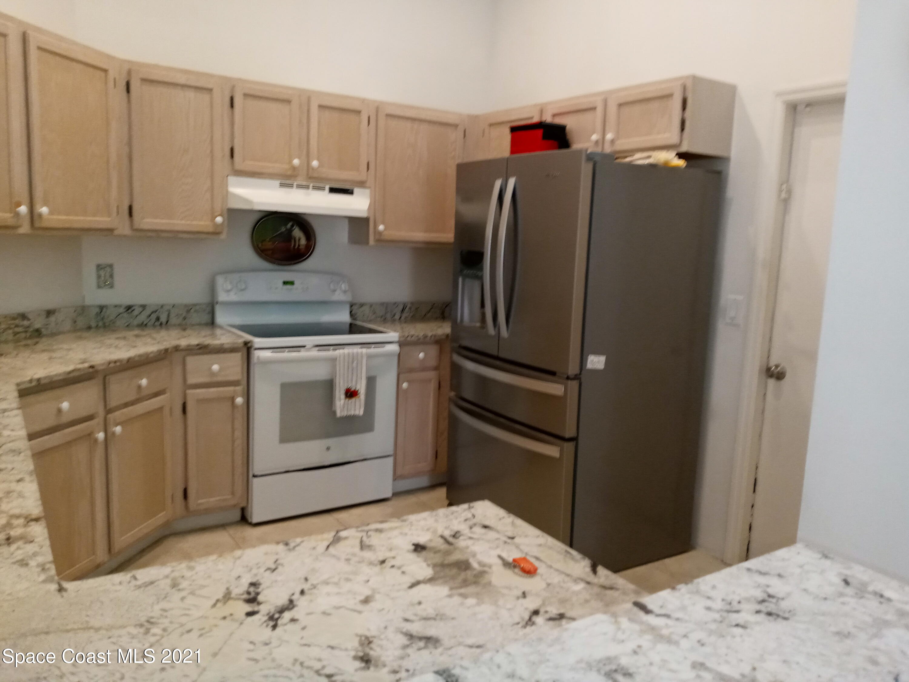798 Riviera Drive Northeast Palm Bay, FL 32905 - Photo 5 of 7 a kitchen with a stove and a refrigerator