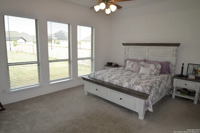 a spacious bedroom with a bed and a chandelier