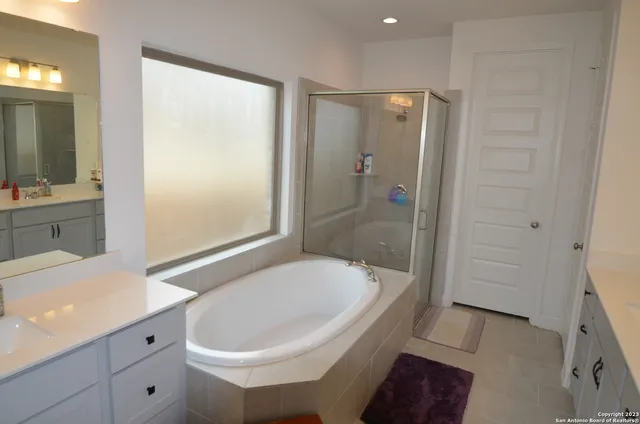 a bathroom with a tub sink and mirror