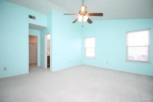 an empty room with a window and a fan