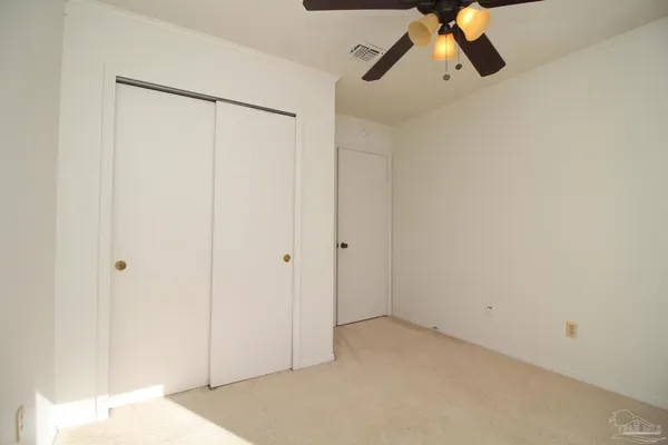 an empty room with a window and a fan