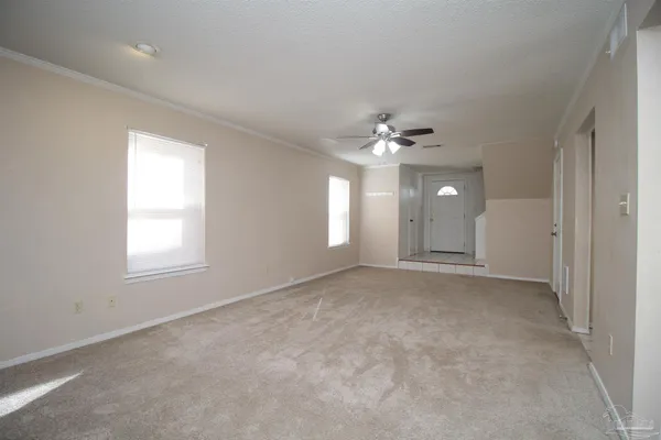 an empty room with window and chandelier fan