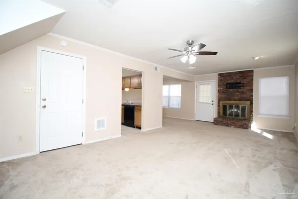 an empty room with fireplace and windows