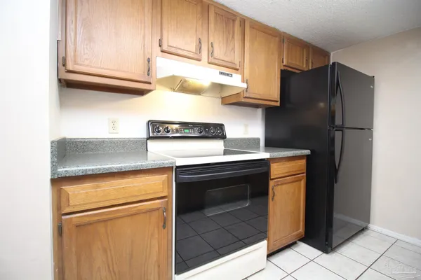 a kitchen with stainless steel appliances granite countertop a refrigerator stove and cabinets