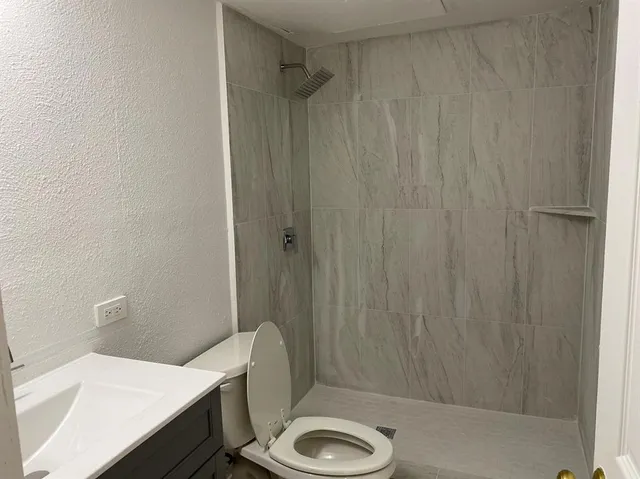 a bathroom with a sink a toilet and shower