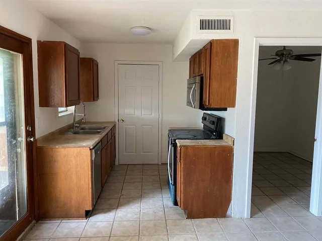 a kitchen with stainless steel appliances granite countertop a refrigerator and a stove