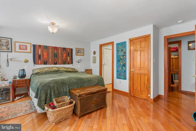 a bedroom with a bed a table and a book shelf