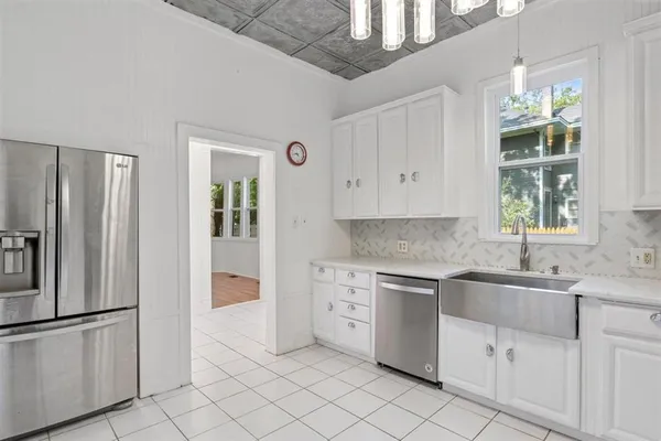 a kitchen with white cabinets and refrigerator