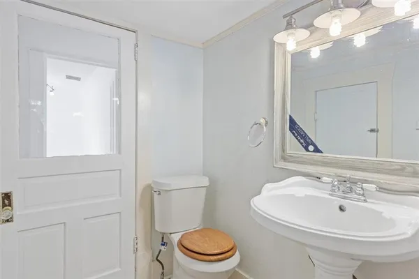 a bathroom with a sink a toilet and a mirror