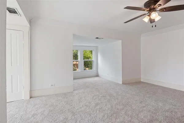 an empty room with fan and windows