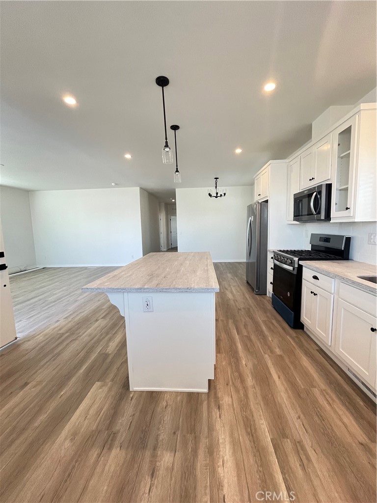 1550 Rimpau Avenue, Unit 42 Corona, CA 92881 - Photo 4 of 22 a large kitchen with stainless steel appliances a large counter top a stove a sink dishwasher and a refrigerator