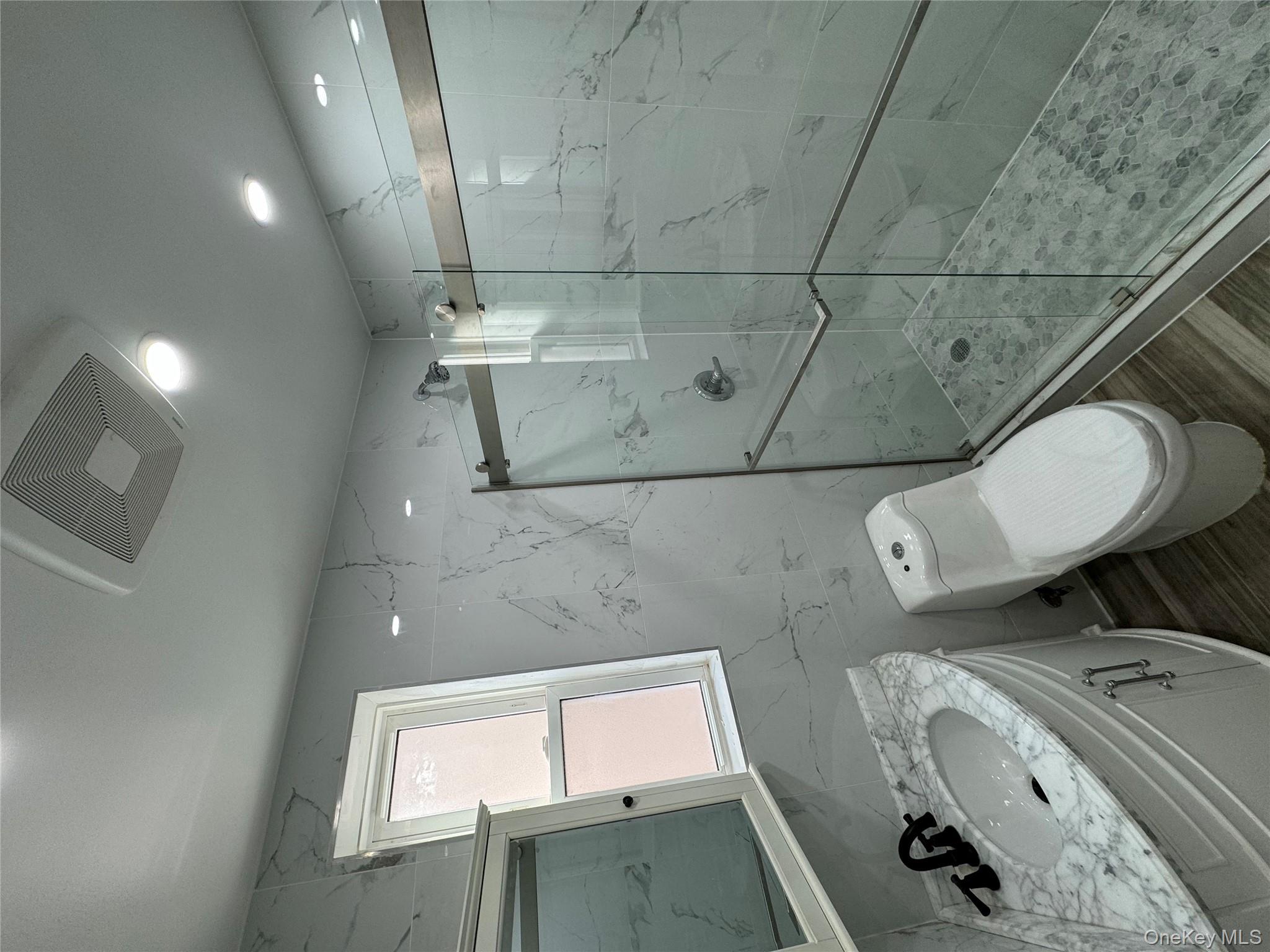 60-03 56th Road, Unit 2 Queens, NY 11378 - Photo 11 of 12 a bathroom with a toilet a sink shower and mirror