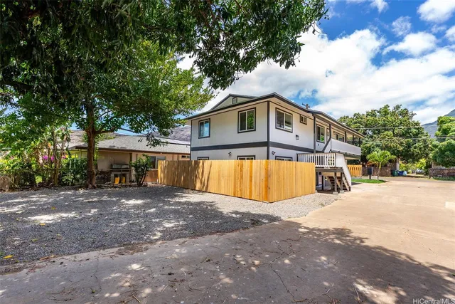 a view of a house with a big yard and large trees