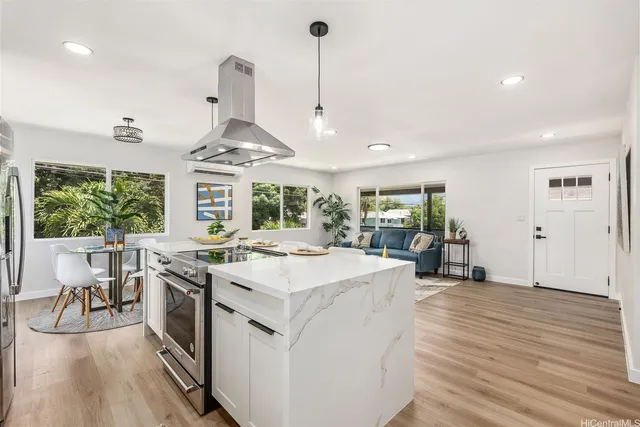 a kitchen with stainless steel appliances granite countertop a stove and a wooden floors