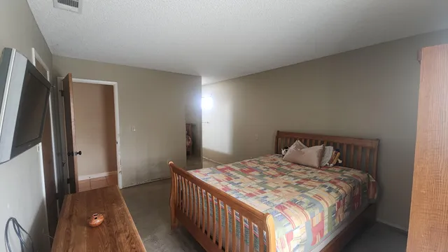 a bedroom with a bed and a large mirror