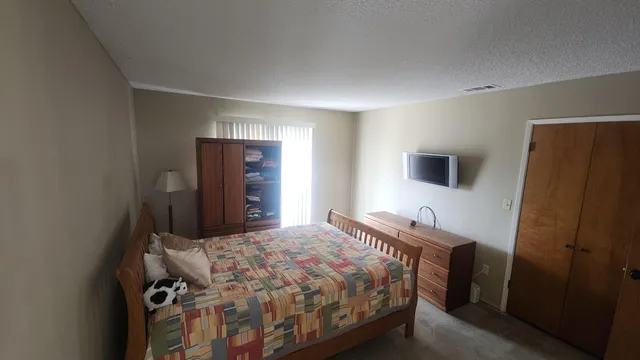 a bedroom with a bed and a flat screen tv