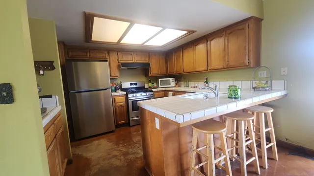 a kitchen with a sink a refrigerator and cabinets