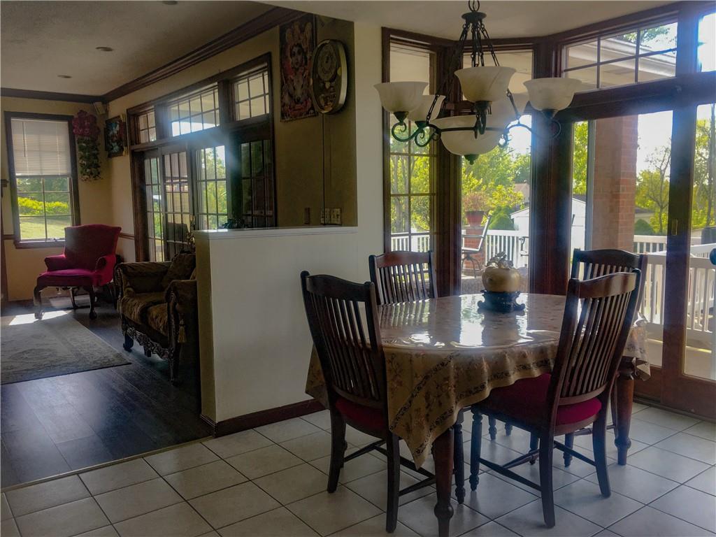 5076 Brownsville Road Pittsburgh, PA 15236 - Photo 16 of 50 a view of a dining room with furniture a chandelier and wooden floor