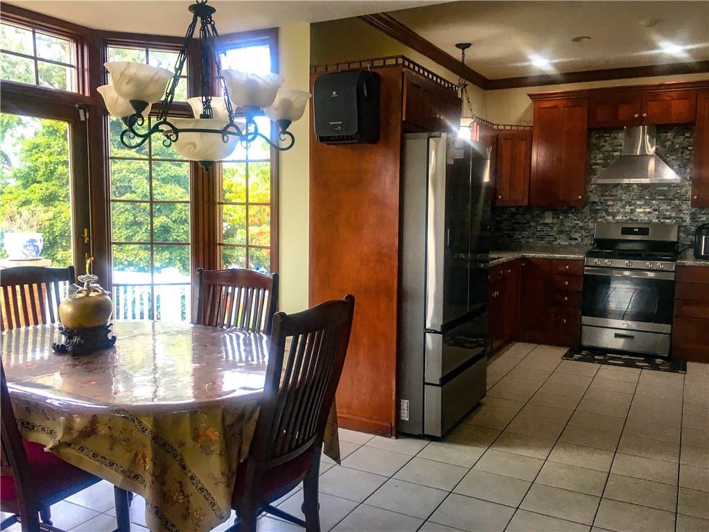 5076 Brownsville Road Pittsburgh, PA 15236 - Photo 17 of 50 a kitchen with stainless steel appliances granite countertop a stove a kitchen island a table and a refrigerator