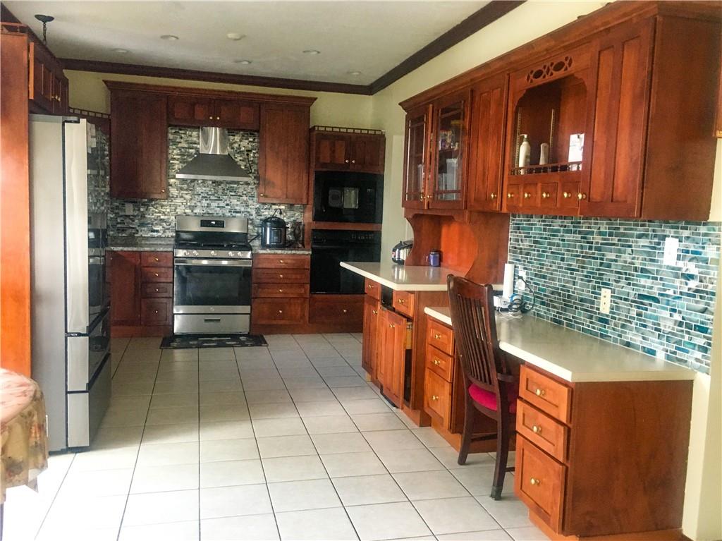 5076 Brownsville Road Pittsburgh, PA 15236 - Photo 18 of 50 a kitchen with stainless steel appliances granite countertop a stove and a sink