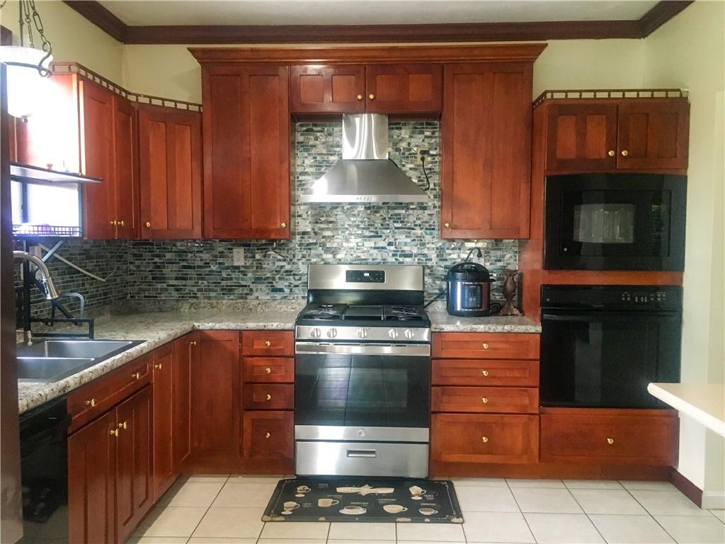 5076 Brownsville Road Pittsburgh, PA 15236 - Photo 19 of 50 a kitchen with stainless steel appliances granite countertop a stove and a microwave