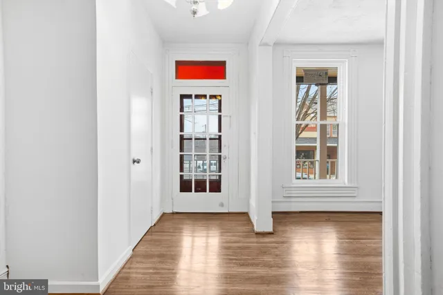 an entryway with wooden floor and windows