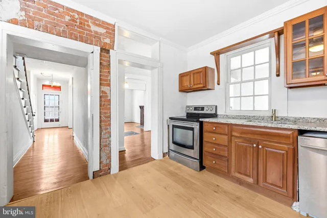 a kitchen with granite countertop a stove a sink and a refrigerator