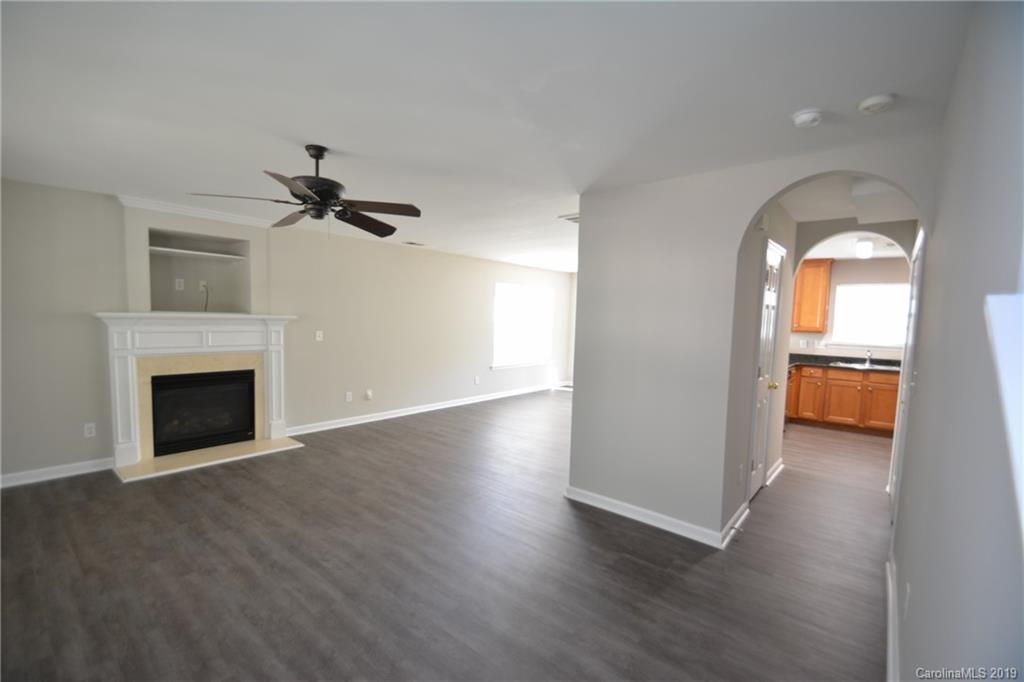 10044 Caldwell Depot Road Cornelius, NC 28031 - Photo 3 of 16 a view of empty room with wooden floor and fireplace