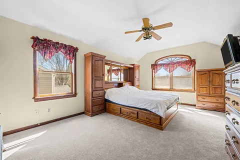 a spacious bedroom with a bed and a chandelier