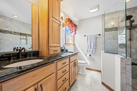 a spacious bathroom with a double vanity sink a mirror and a shower