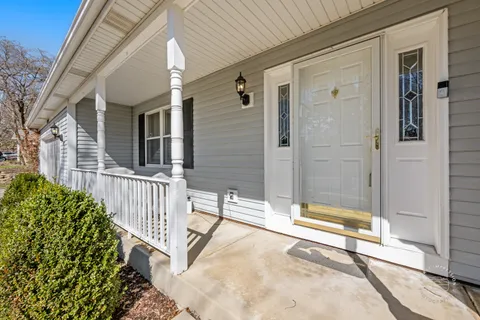 a view of a house with a small yard and wooden floor and fence