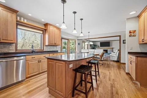 a kitchen with stainless steel appliances granite countertop wooden floors stove top oven and sink