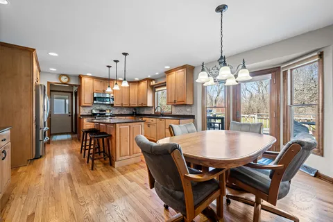 a dining room with furniture a chandelier and wooden floor
