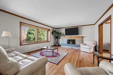 a living room with furniture a large window and a fireplace