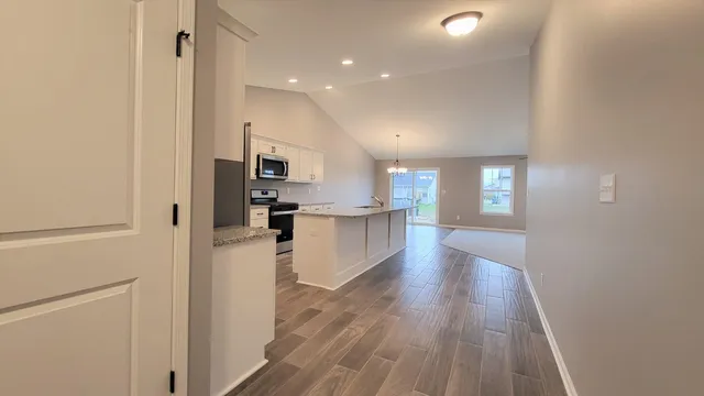a view of a kitchen with wooden floor and electronic appliances