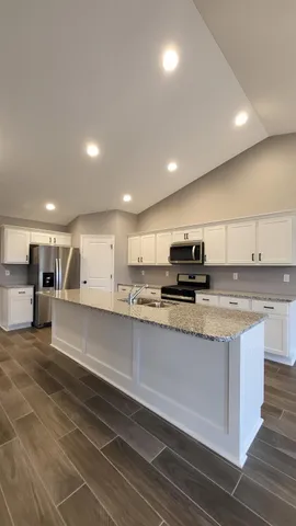 a kitchen with stainless steel appliances granite countertop a sink and cabinets