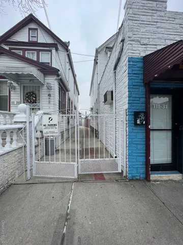 a view of a house with a small yard and wooden fence