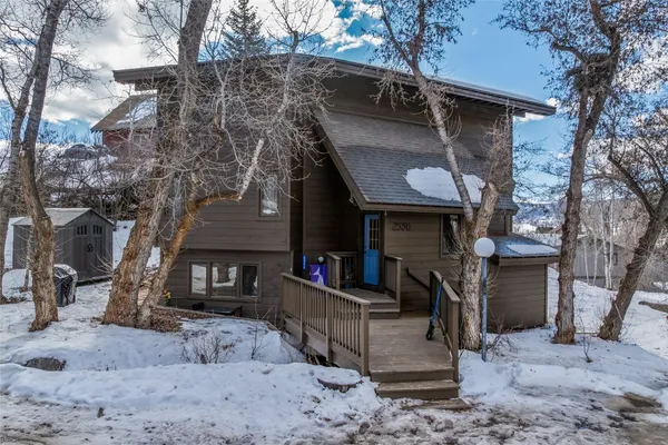 a view of a house with a yard covered with snow in the background