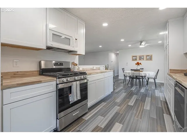 a kitchen with stainless steel appliances kitchen island granite countertop a stove a sink and a microwave