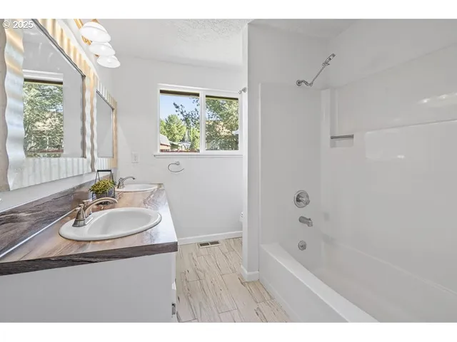 a bathroom with a tub sink and mirror