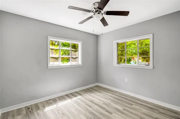 a view of empty room with window and ceiling fan