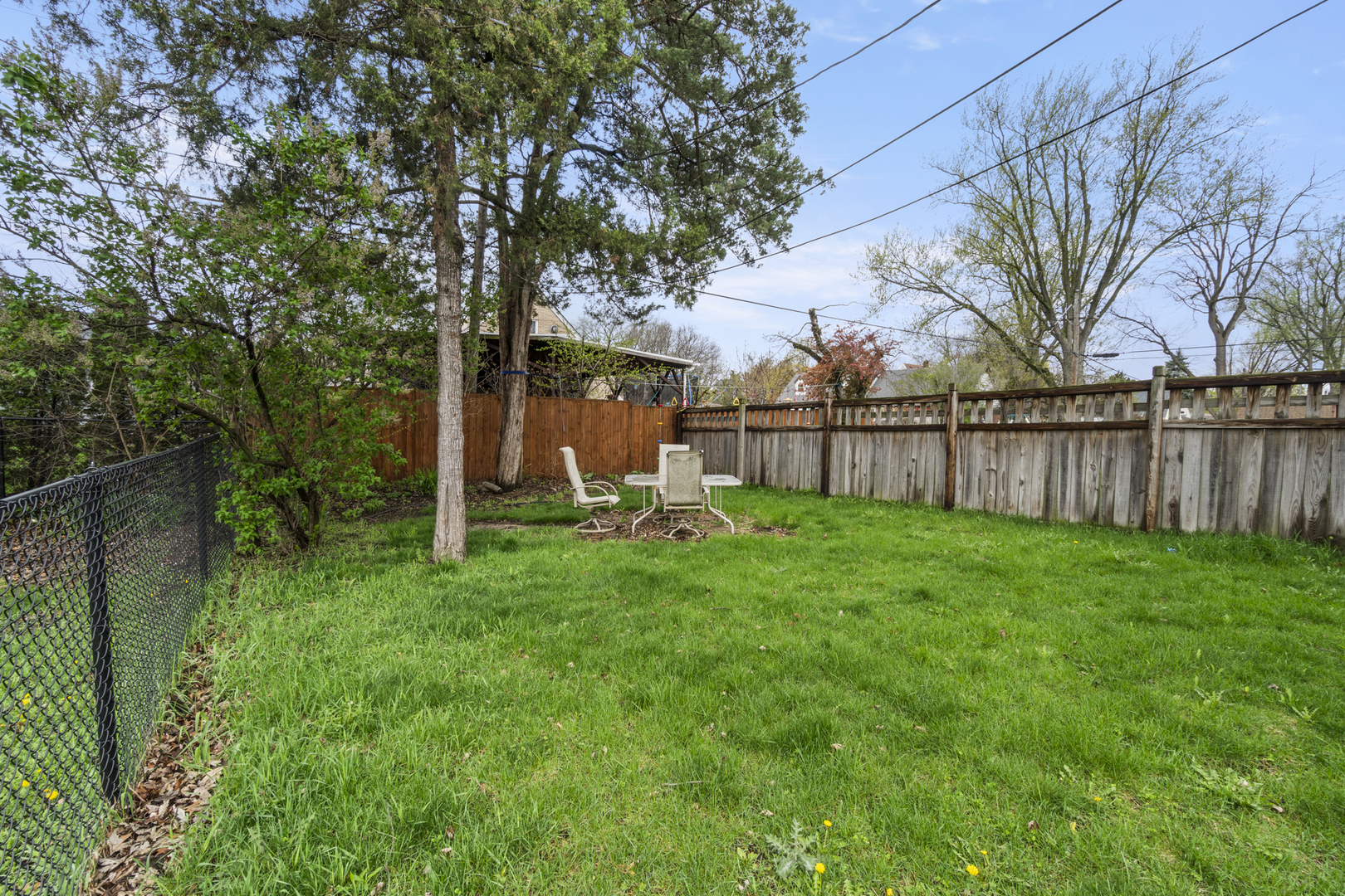 853 Orange Street Elgin, IL 60123 - Photo 21 of 28 a view of a backyard with large trees and wooden fence
