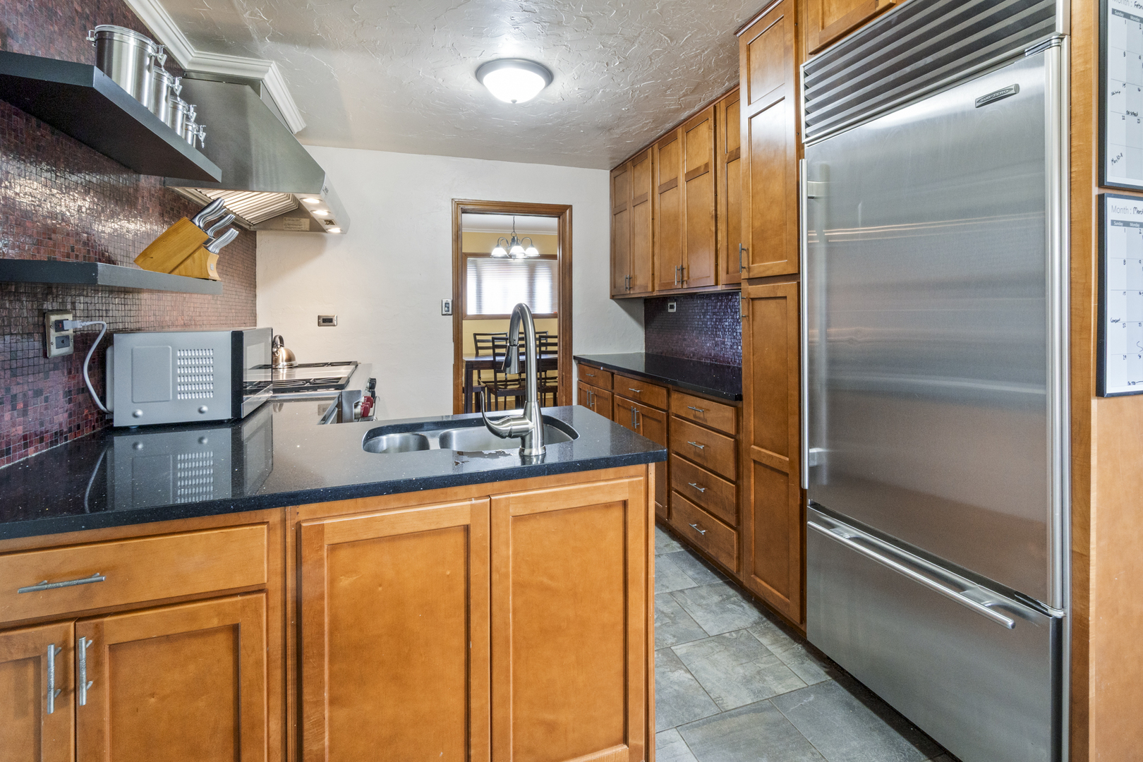 853 Orange Street Elgin, IL 60123 - Photo 7 of 28 a kitchen with granite countertop stainless steel appliances and wooden cabinets