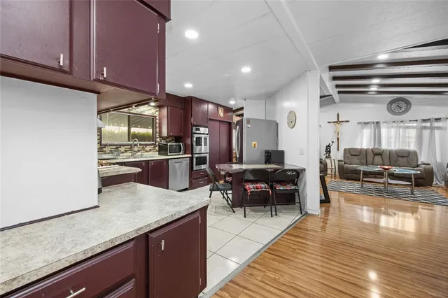 a kitchen with stainless steel appliances granite countertop a stove a sink dishwasher and cabinets with wooden floor
