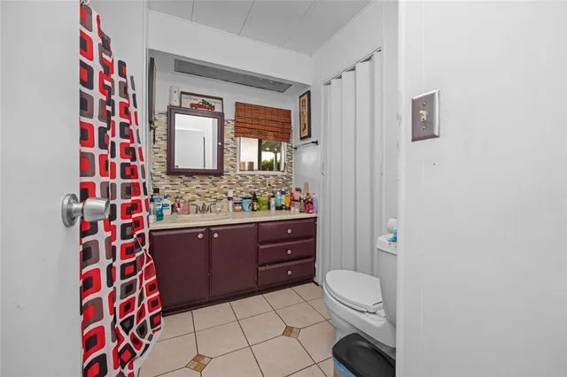 a bathroom with a sink a toilet and shower curtain