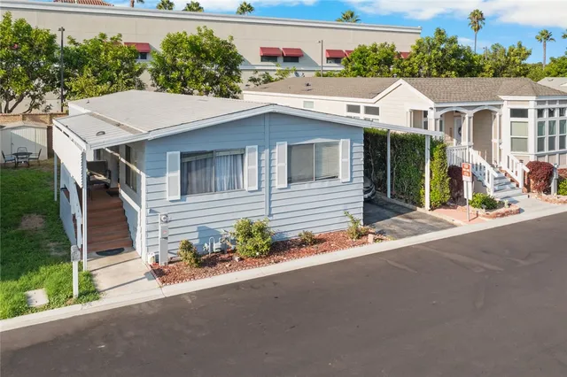 a view of a white house with a large windows and plants